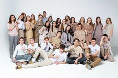 a group of young people posing for a photo in front of a white background with one person giving the peace sign