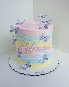 a cake decorated with butterflies and the word heaven on it's top is sitting on a plate