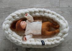 a baby doll is laying in a basket