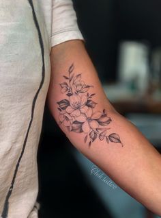 a woman's arm with a flower tattoo on the left side of her arm