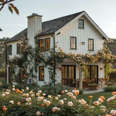 a white house with lots of flowers in front of it