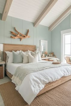 a bed with white linens and pillows in a bedroom next to a large window