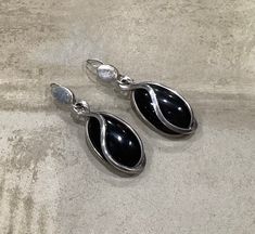 A pair of Taxco Mexico sterling silver and onyx pierced earrings.  The onyx stone is set in a swirl sterling silver cage design.   Hallmarked with the Eagle Three 3, measuring ~2 inches long and ~3/4 inches wide. Black Cabochon Earrings For Evening, Evening Black Cabochon Earrings, Silver Onyx Earrings For Formal Occasions, The Eagle, Funky Jewelry, Jewelry Lookbook, Swirl Design, Onyx Stone, Pierced Earrings