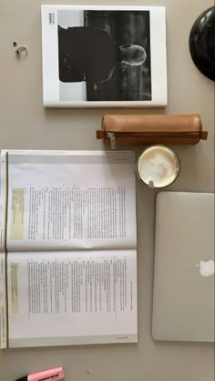 an apple laptop computer sitting on top of a desk next to papers and other items