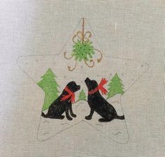 two black dogs sitting next to each other on top of a white cloth covered table