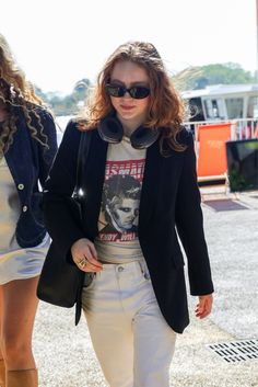 a woman walking down the street in white pants