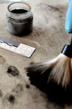 a brush and some ink sitting on a table next to a paint container with paw prints