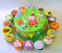 a birthday cake decorated with cupcakes and animals