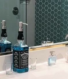 two bottles of alcohol sitting on top of a bathroom counter