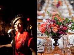 a woman holding a microphone next to a table with flowers and wine glasses on it