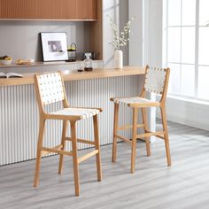 two wooden stools sitting in front of a counter