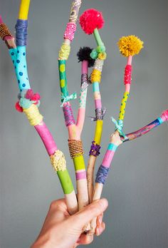 a vase filled with lots of different colored toothbrushes and pom - poms