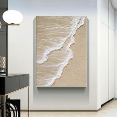 a white and beige painting on the wall next to a black table in a room