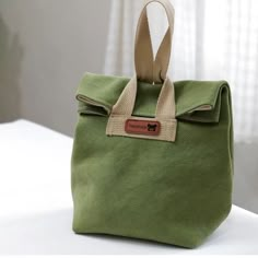 a green bag sitting on top of a white table