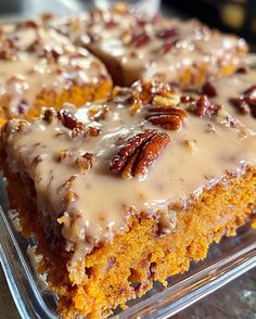 there is a piece of cake with pecans on top in the glass dish that is ready to be eaten