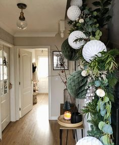 the hallway is decorated with greenery and white paper lanterns hanging from the ceiling, along with other decorations