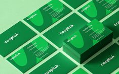 green business cards with the company name and logo printed on them, arranged in rows