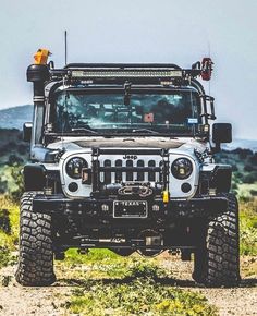 a jeep is parked on the side of a dirt road