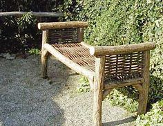 a wooden bench sitting in the middle of a garden next to bushes and shrubbery