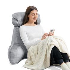 a woman sitting in a reclining chair holding a cell phone