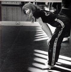 black and white photograph of a woman in the middle of a dance floor with her hands on her hips