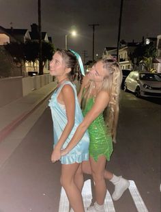 two girls in dresses walking down the street