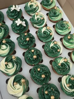 cupcakes with green frosting and gold sprinkles in a box