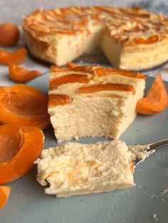 a piece of cheesecake on a plate next to sliced oranges