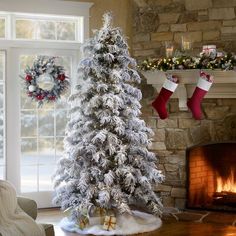 a decorated christmas tree in front of a fireplace