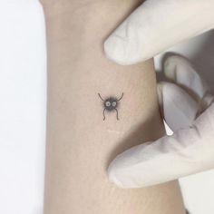 a small spider tattoo on the left side of the right arm is shown in black and white