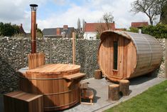 a wooden hot tub sitting next to a stone wall