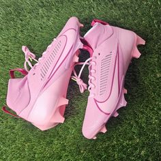 a pair of pink shoes sitting on top of green grass