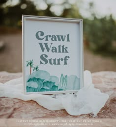 a sign that reads crawl walk surf sitting on top of a rock with white fabric around it