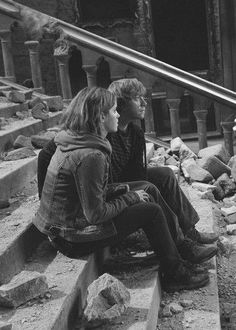 black and white photograph of two people sitting on steps