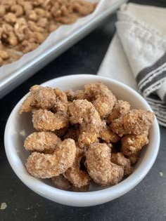 a bowl filled with sugared donuts next to a tray of cereal