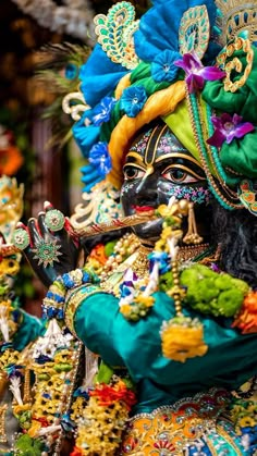 a man dressed in colorful clothing holding a pipe and wearing an elaborate headdress