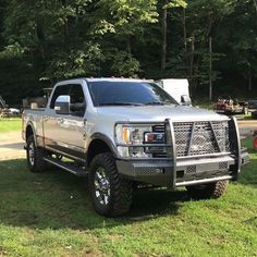 a silver truck is parked in the grass