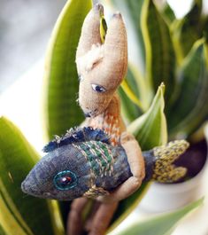 a stuffed animal sitting on top of a plant