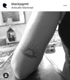 a black and white photo of a person's foot with a sun tattoo on it