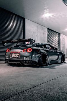 a black sports car parked in front of a garage