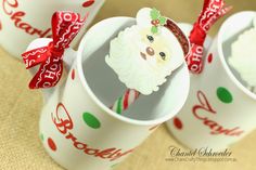 three cups with candy canes in them and santa's face on the top