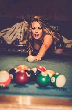 a beautiful woman leaning over a pool table