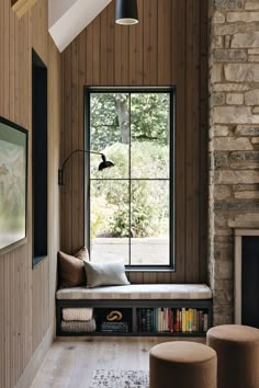 a window seat in front of a book shelf with books on it next to a fireplace