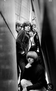 the rolling stones are posing for a photo in an escalator with their heads down