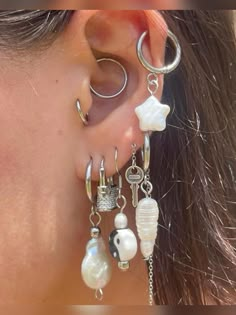 a close up of a person's ear with earrings and rings attached to it