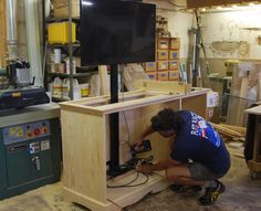 a man working on a cabinet in a shop