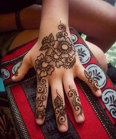 a woman's hand with henna tattoos on it