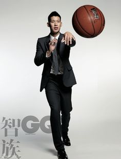 a man in a suit and tie holding a basketball