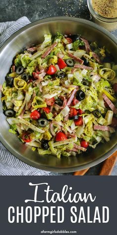 an italian chopped salad in a bowl with olives and tomatoes