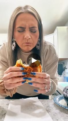 a woman sitting at a kitchen counter looking at a plate with food on it,